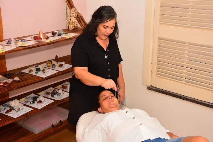 Nayyara em sua sala de terapia com pedras e cristais